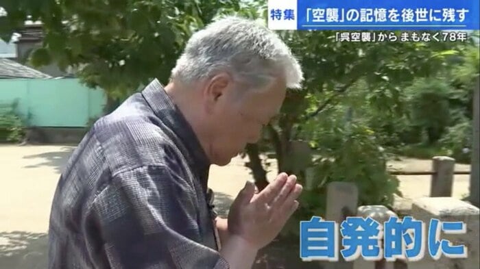 呉市本町の寺西公園の戦災犠牲者供養塔に手を合わせる朝倉さん