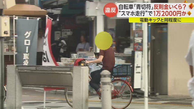 スマホを見ながら自転車に乗る人