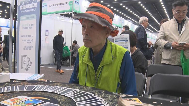 占い師に就職先を相談する男性（65）