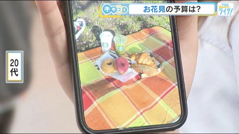 広島市中区の東千田公園で撮影した写真を見せる女性