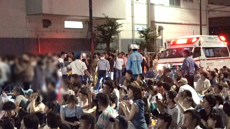 緊急車両用の道路に人が座り込み、進むことができない救急車