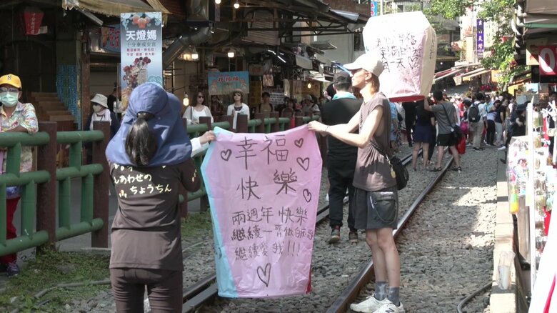 線路の中でランタン上げをする観光客