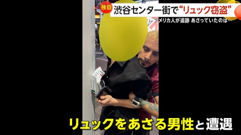 リュックを漁る男性と遭遇し取り押さえているアメリカ人カメラマン