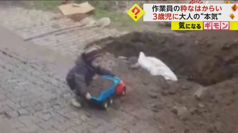 おもちゃのトラックを両手で抱える男の子