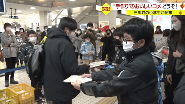 収穫したお米を配布する子どもたち