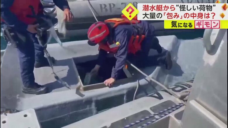 潜水艇のハッチを開け、中を確認する海軍