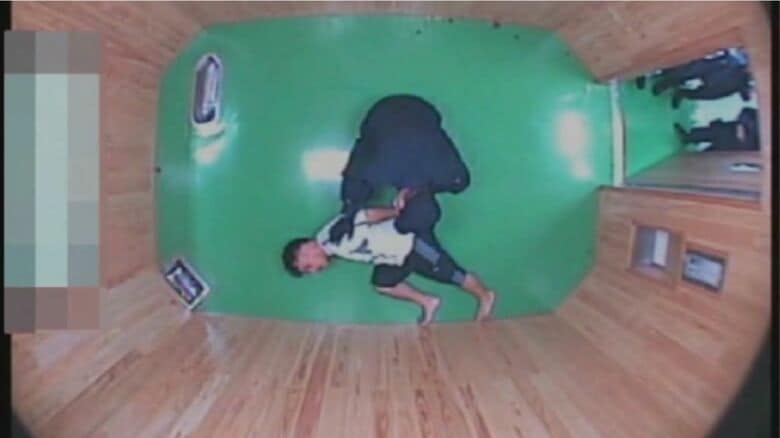 職員に制圧されるフジイさん（弁護団提供）