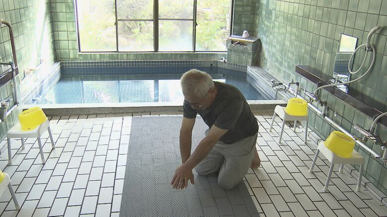 倒れている男性に胸骨圧迫（心臓マッサージ）※再現