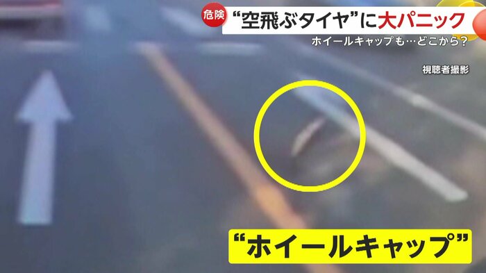 道路を転がるホイールキャップ