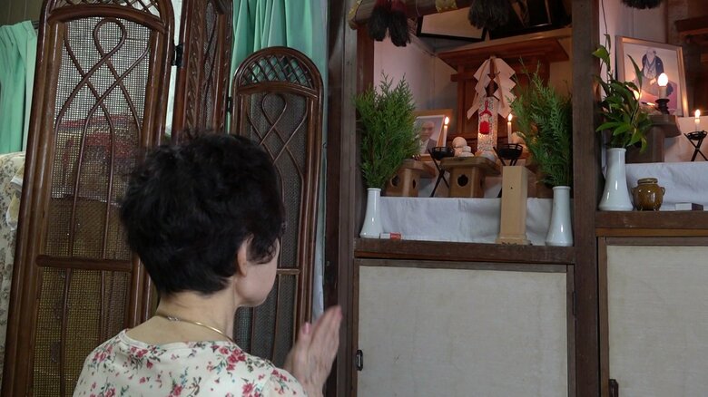 仏壇に手を合わせる田崎さん