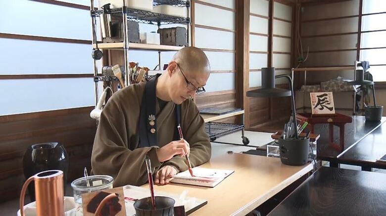 児玉住職が一枚一枚丁寧に筆を入れる