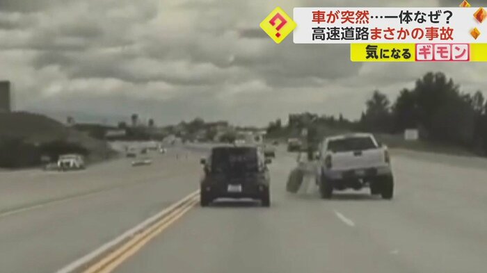 白い車のタイヤが外れ…