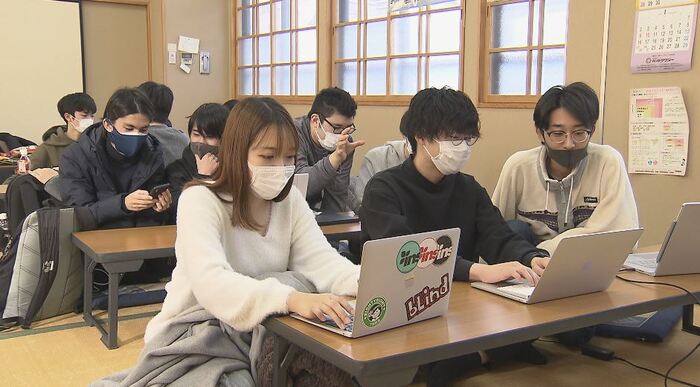 パソコンと向かい合う若者たち
