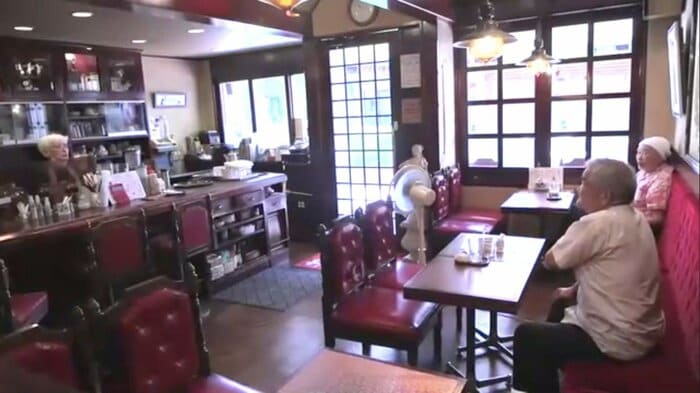 カウンター越しに客と話す店主・小野康子さん(77)