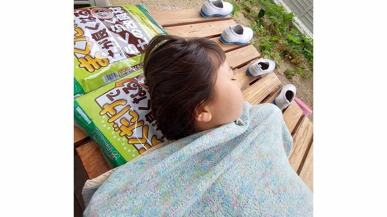 土を枕に縁側でお昼寝をする娘さん
