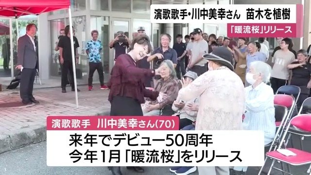 『暖流桜』の音楽に合わせて 参加者と手を振る川中美幸さん