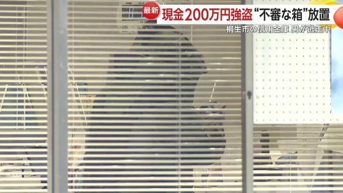 防護服を着た機動隊員が店舗内で作業する様子