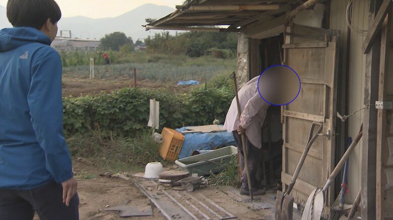 「ヤミ畑」で作業中の男性に記者が話しかける