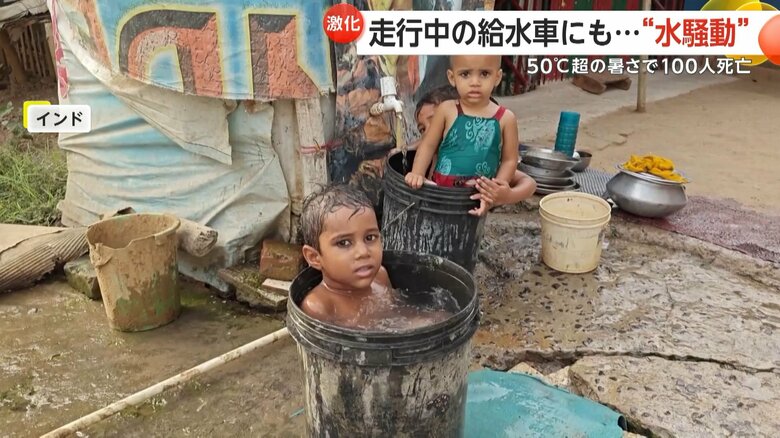 暑さをしのぐため、バケツの水につかる子どもの姿
