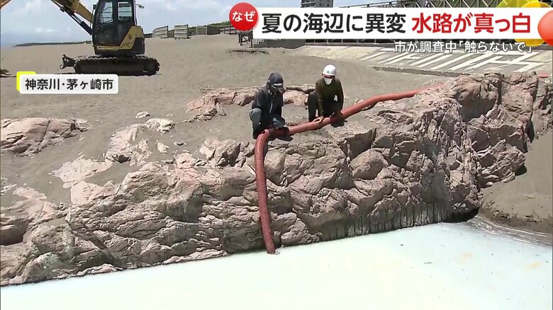 砂でせき止めホースなどを使って行われている汲み取り作業