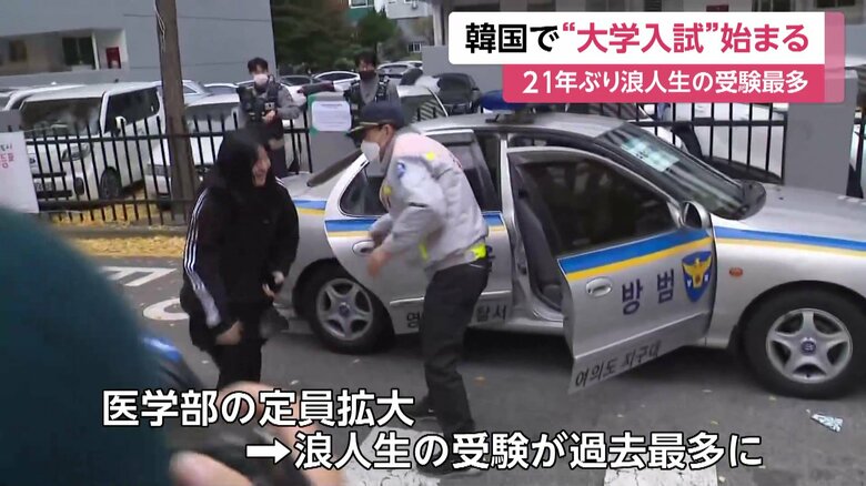 パトカーで会場入りする受験生