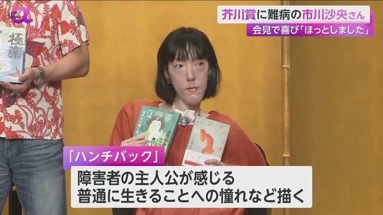 受賞作『ハンチバック』が掲載された本を手に持つ市川さん