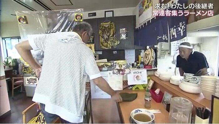 客を見送る西村さん(右)