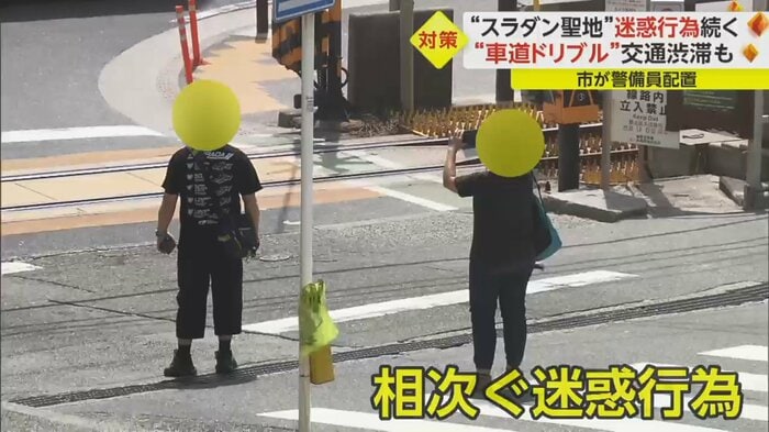 車道の真ん中で写真撮影する人たち