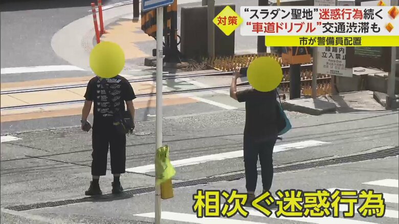 車道の真ん中で写真撮影する人たち
