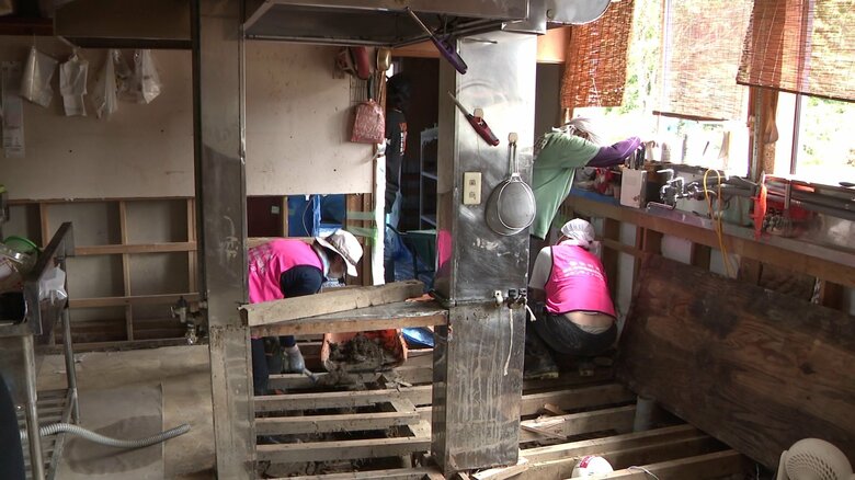 ボランティアによる厨房床下の泥のかき出し作業