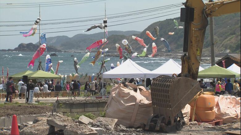 重機と海に向かって悠々と泳ぐこいのぼり