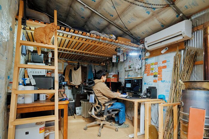 かずひろさんの小屋の内部。中古で購入した3,600W分の太陽光パネルで、電気はほぼ自給できているそう(写真/星 亘)