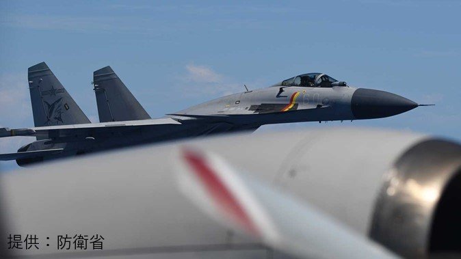 手前が自衛隊哨戒機、奥に確認できるのが中国軍の戦闘機(提供:防衛省)
