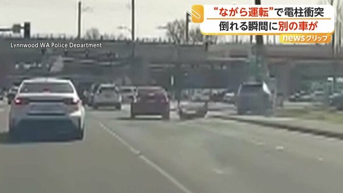 右手の電柱に衝突した黒い車