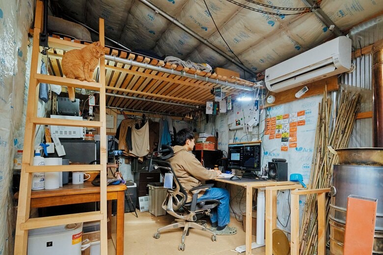 かずひろさんの小屋の内部。中古で購入した3,600W分の太陽光パネルで、電気はほぼ自給できているそう（写真／星 亘）