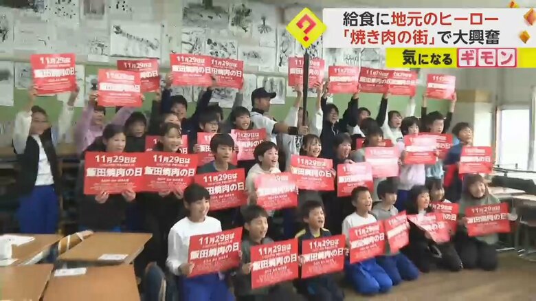 小学生と記念撮影をするニッチローさん