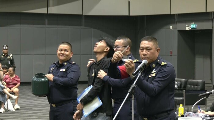 黒（免除）を引き、思わず笑顔と安堵がこぼれる若者