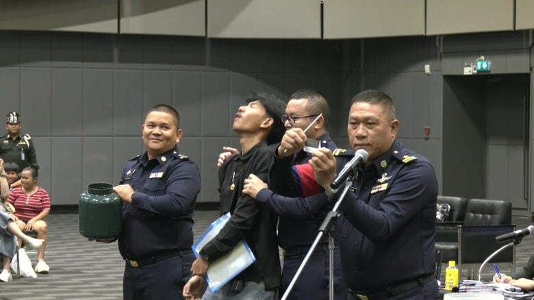 黒（免除）を引き、思わず笑顔と安堵がこぼれる若者