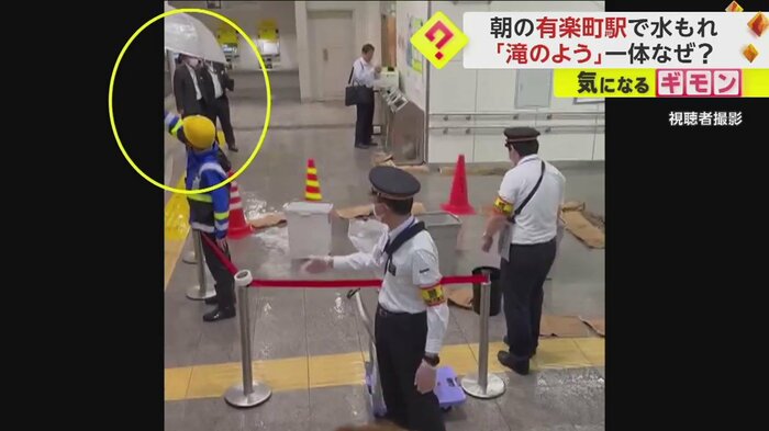 作業員が構内で傘をさしている
