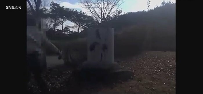石碑に墨汁のようなものを掛ける様子(SNSより)