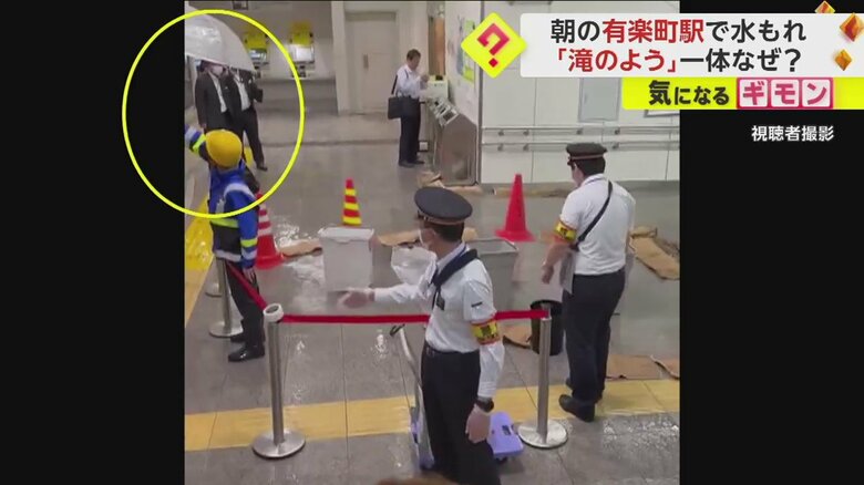 作業員が構内で傘をさしている