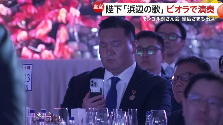 陛下が演奏される様子を撮影する白鵬さん