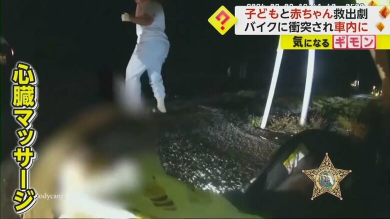 車から救出した赤ちゃんに心臓マッサージをする警察官