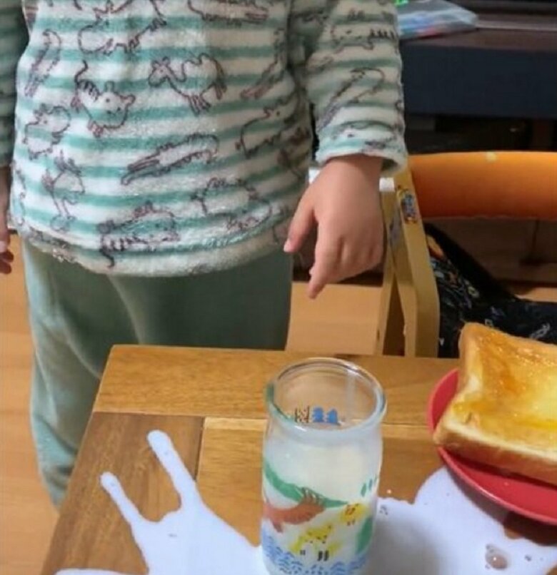 牛乳をこぼしてしょんぼりする息子さん
