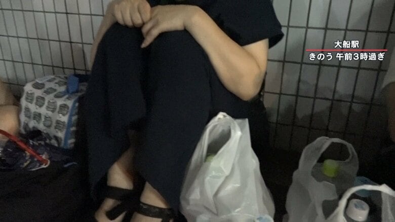 座り込む母親、横には眠っている娘が