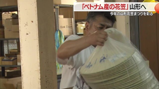 積み荷をほどき、ベトナム産の笠をうれしそうに箱から出す逸見社長