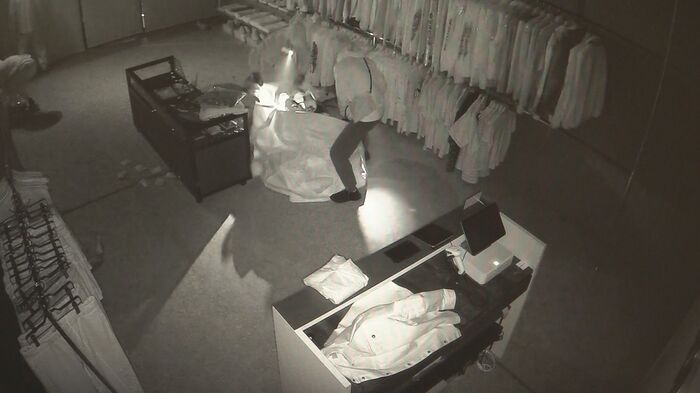 大きな袋に商品を入れる窃盗犯