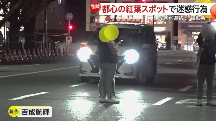 車が走るその横では、車道に出て記念撮影をしている2人組