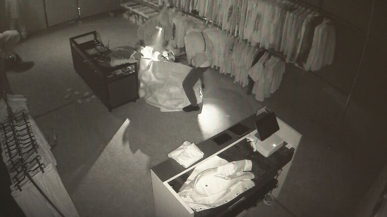 大きな袋に商品を入れる窃盗犯