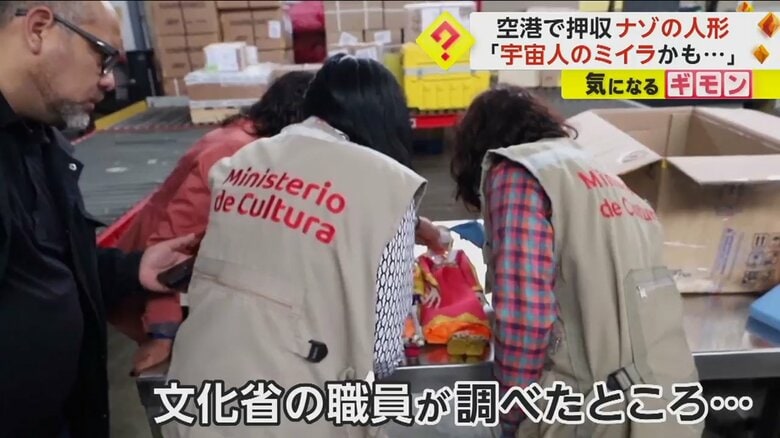 ナゾの人形を調査する文化省の職員